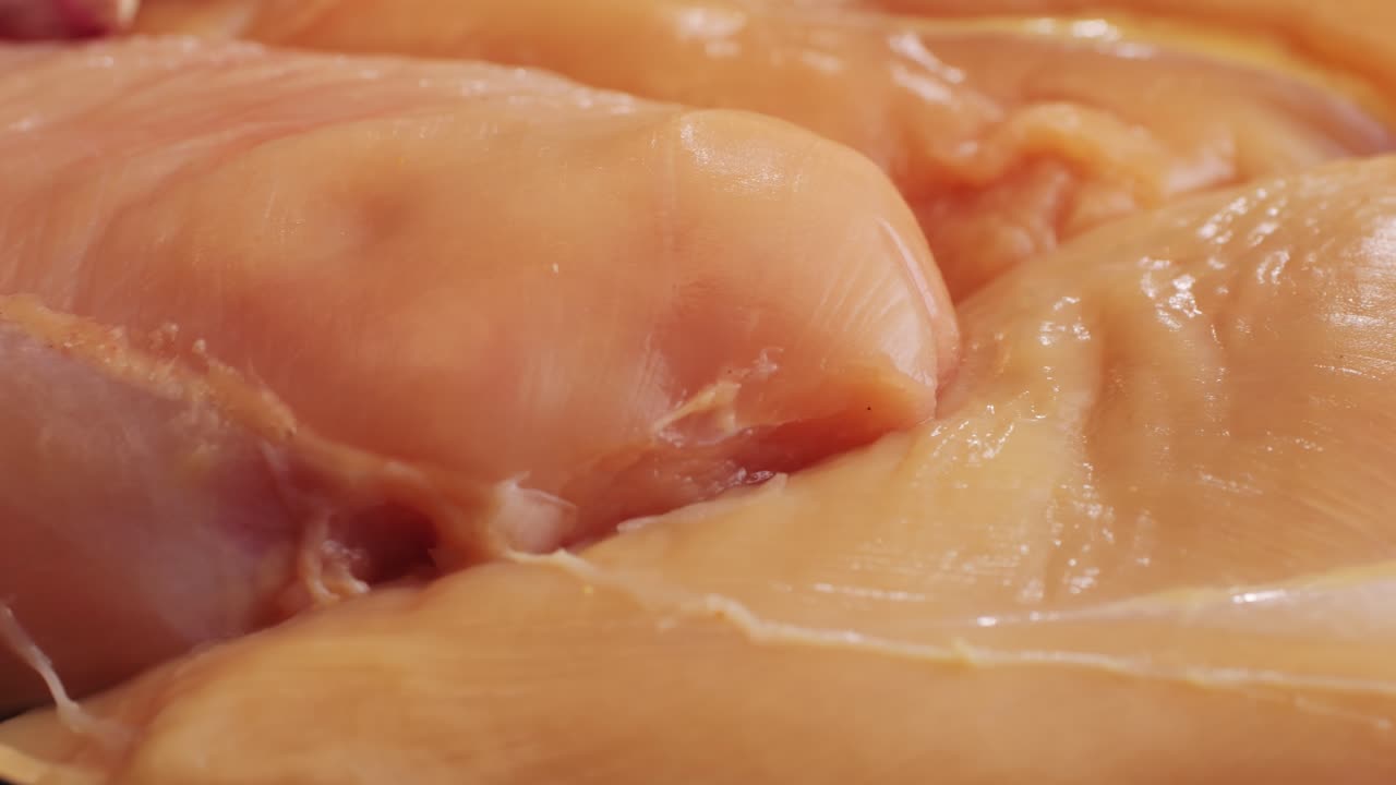 Raw slice chicken meat in spices: paprika, salt, pepper, turmeric on plate close-up. Preparing raw food for cooking. Grilled chicken, duck, turkey kebab with vegetables.