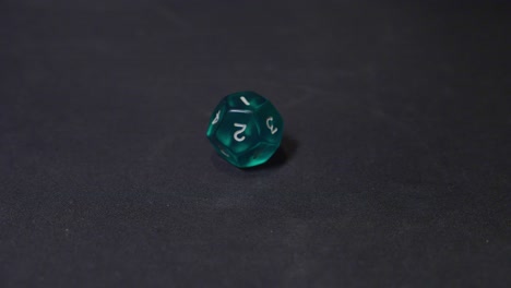 twelve face green dice rolling on the black surface, slow motion