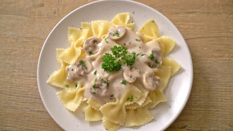 pasta farfalle con salsa de crema blanca de champiñones - estilo de comida italiana