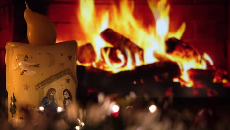 christmas candle with lights and garland decoration in front of fireplace at home