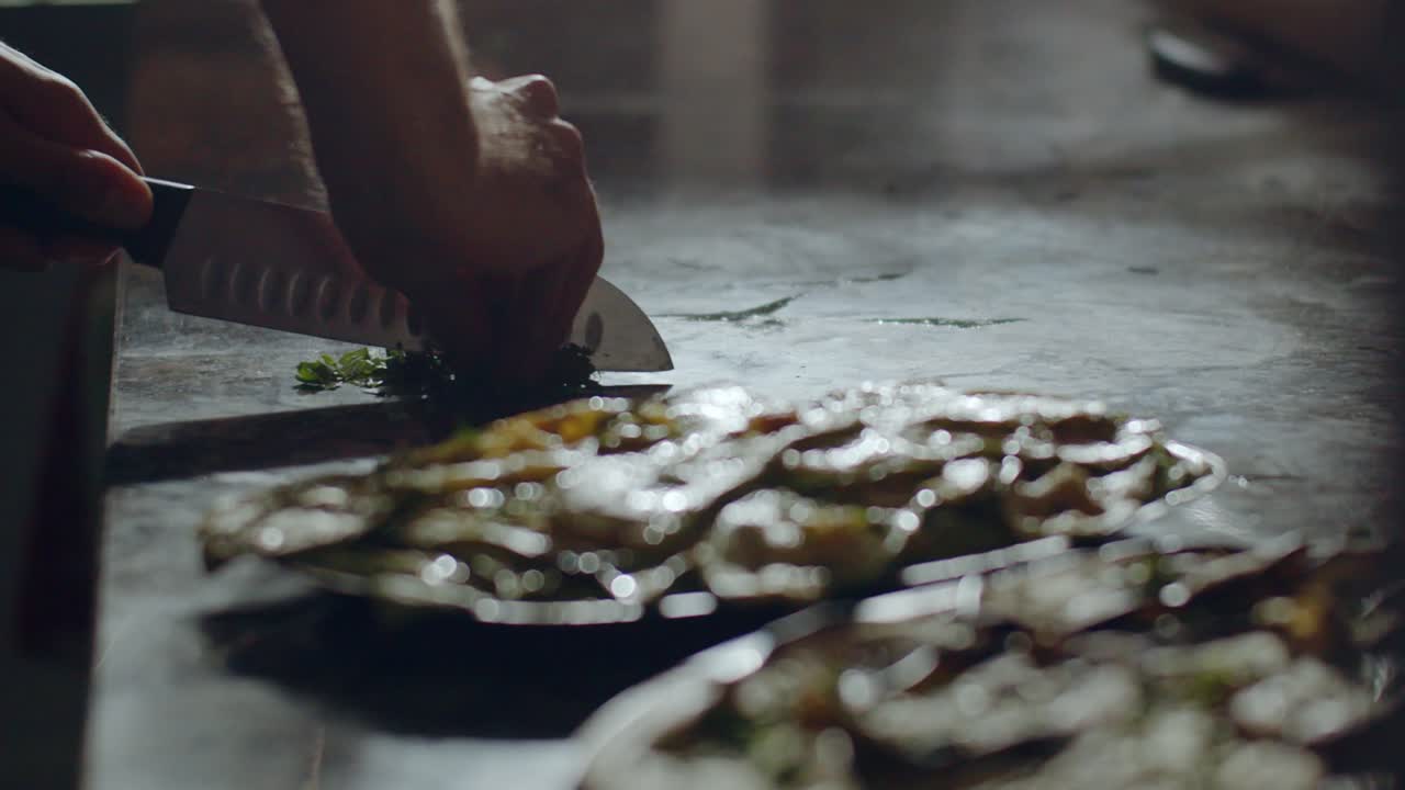 피자 메이커 가 주방 에서 파슬리 를 자르고 있다