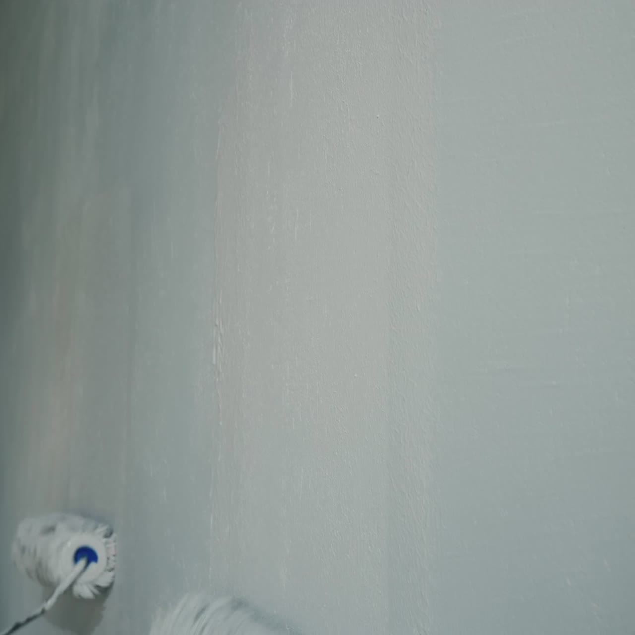 Two People Paint The Wall With Painting Rollers