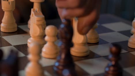 man skillfully positions knight unto chessboard - close up shot