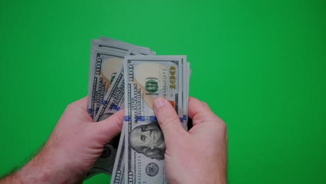 count of money from hand to hand on a green background.