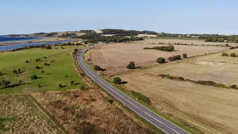 Vista-Aérea-De-La-Costa-De-Sejerøbugten-Con-Vejrhøj,-Carretera,-Campos-Y-Océano