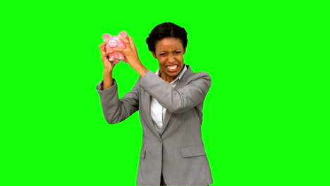 Businesswoman-listening-to-an-empty-piggy-bank-on-green-screen