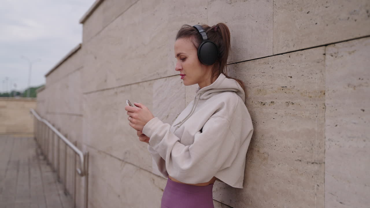 mujer escuchando música y usando el teléfono