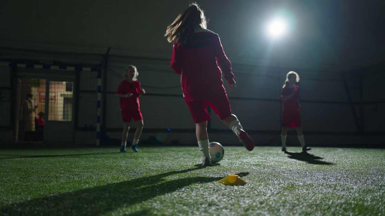 어린 소녀 들 은 밤 에 실내 축구 를 연습 한다