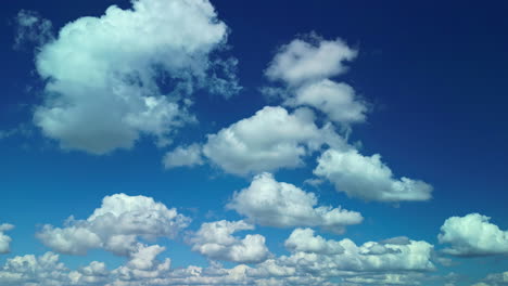 beautiful cumulus clouds moving across the deep blue skies in a slow timelapse motion