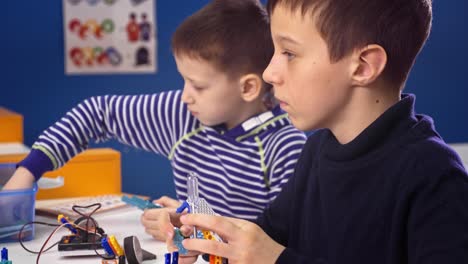 two boys building robots in class