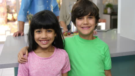 brother and sister posing for the camera while parents watching them