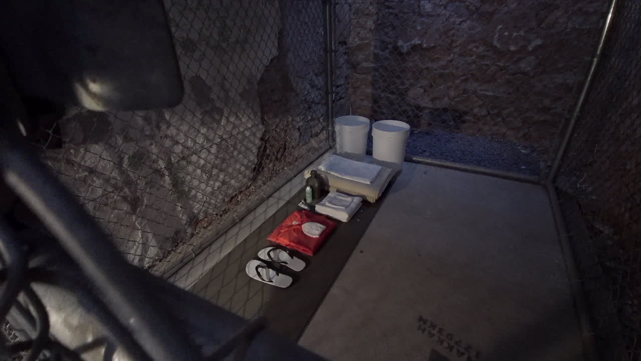 관타나모 베이 수용소 스타일 감옥의 체인 링크 울타리를 통해 보기