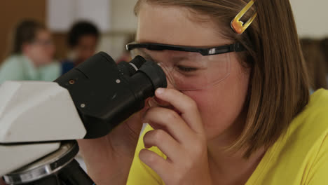 Girl-wearing-glasses-using-microscope-