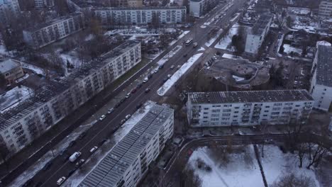 gray overcast day with snowfall over apartment building district in russia, drone view