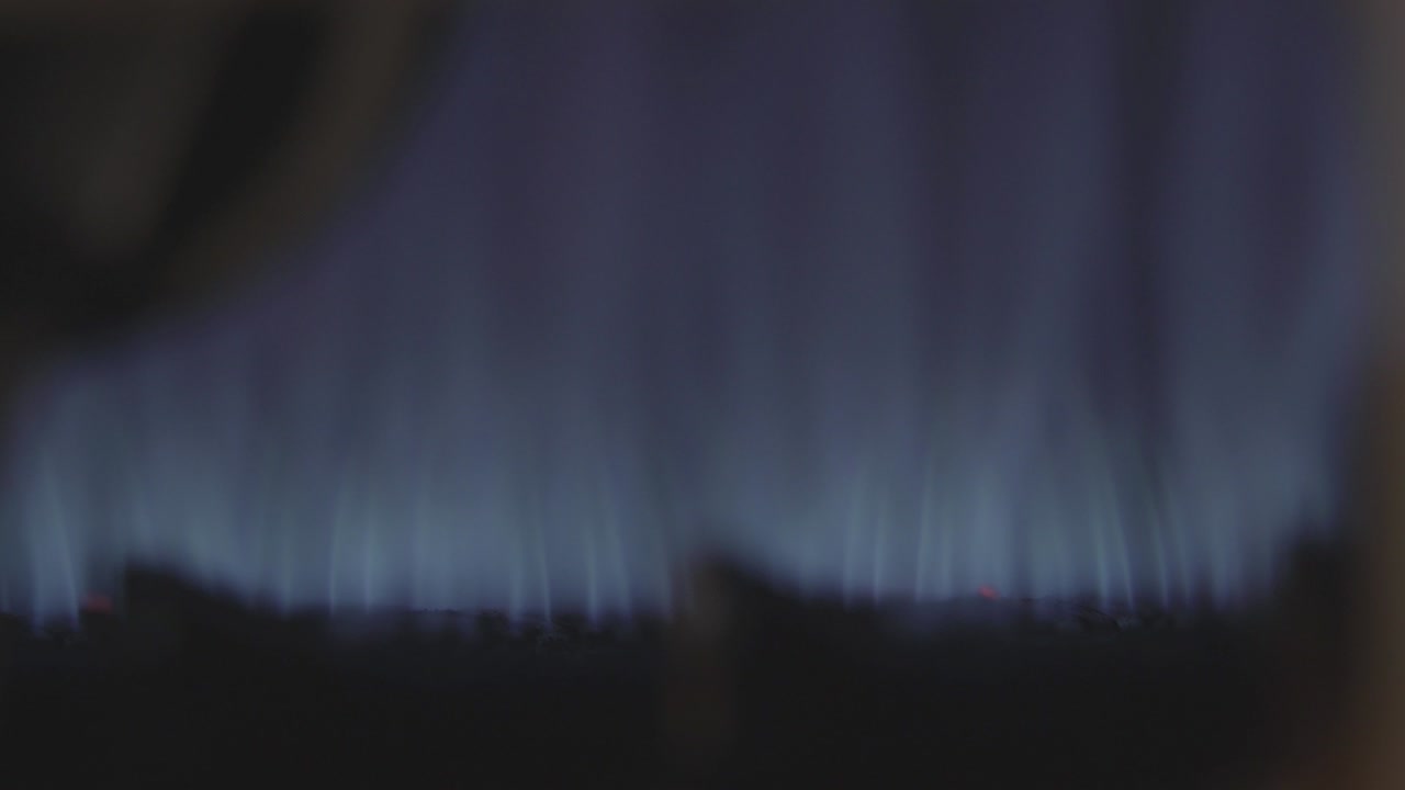 macro disparo de la llama que se quema en el quemador. primer plano de la ignición azul en la estufa de gas. cocina, cocina, olla de cocción, equipos domésticos