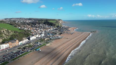 aerial drone shot of hastings uk, wide tracking shot of the land based fishing fleet of beach, old town and east hill cliff and coast line