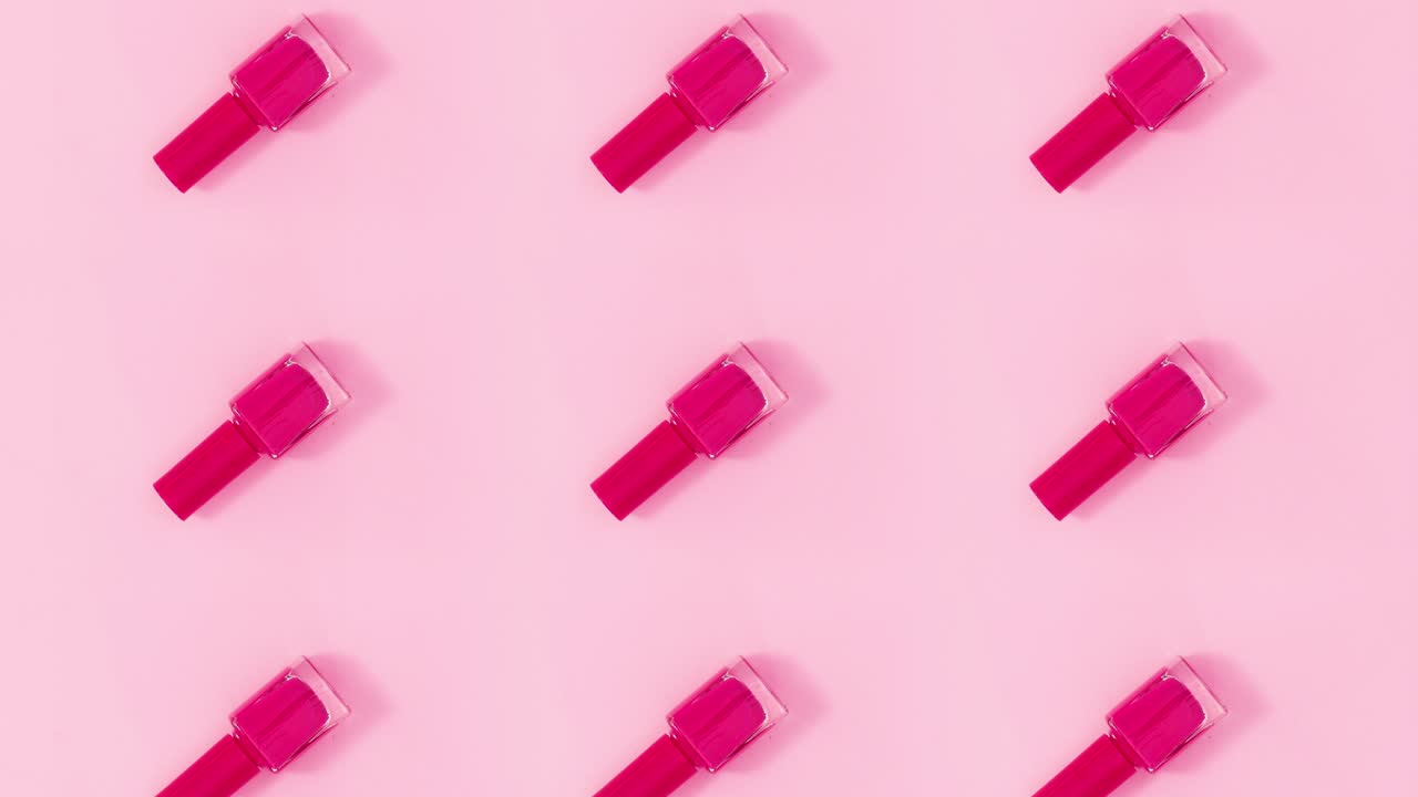 patrón de concepto de belleza hecho de esmalte de uñas botellas del mismo color girar en tema rosa brillante. detener el movimiento