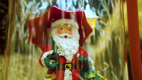 toy santa claus with an umbrella under the falling snow