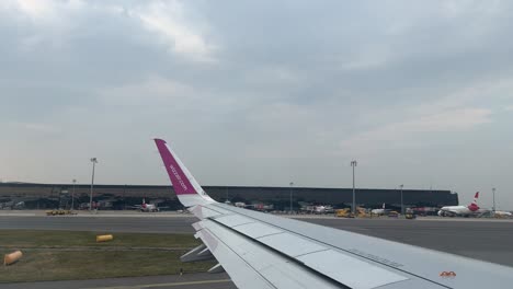 Wizz-Air-Plane-Wing-In-The-International-Airport-Of-Vienna,-Flughafen-Wien-schwechat-During-The-Day-4k