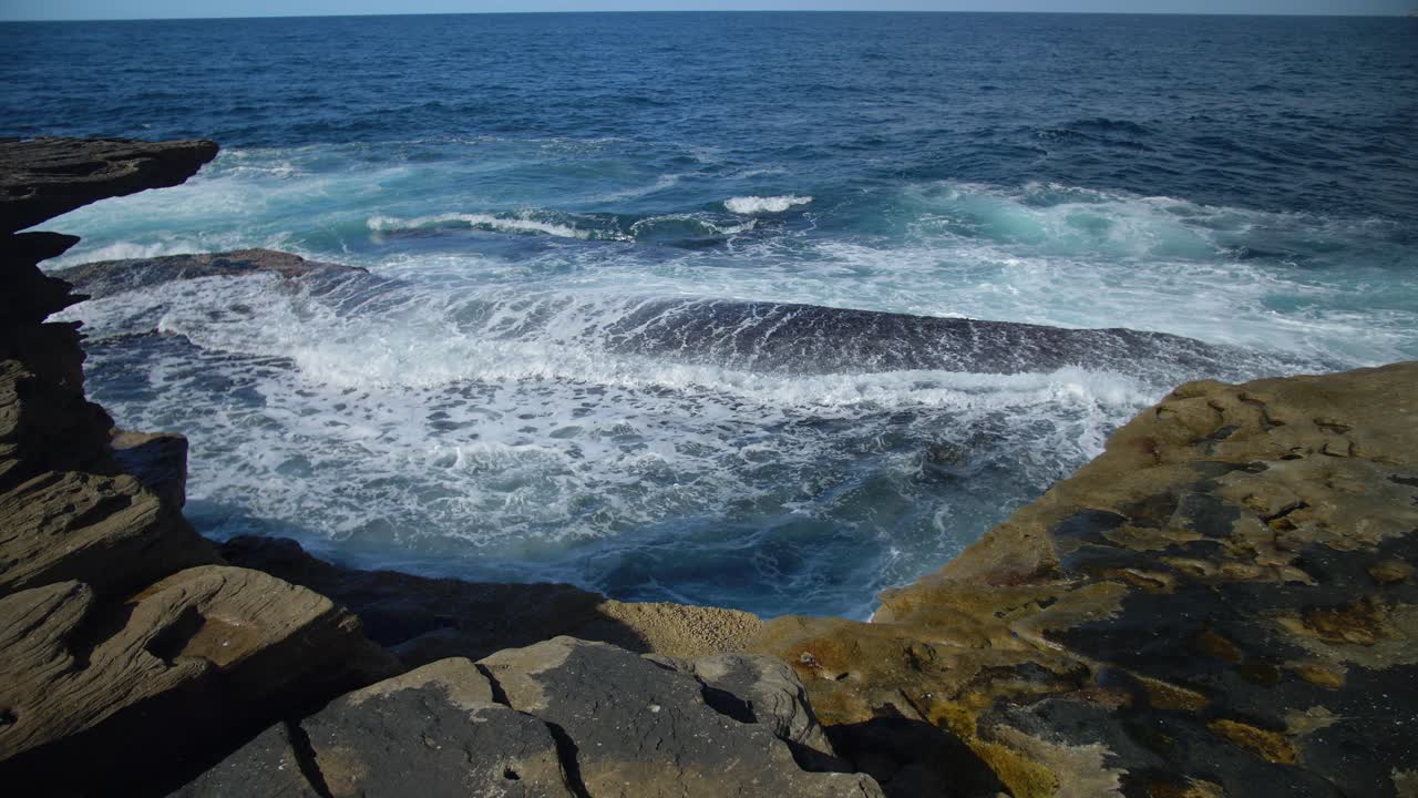 olas del océano salpicando en la costa rocosa - suburbios del este en sydney, nueva gales del sur, australia