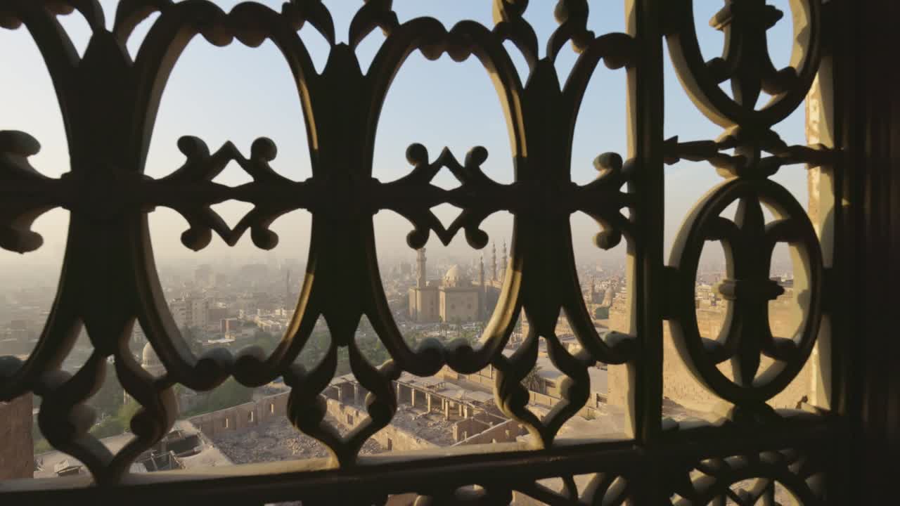 vista de la ciudad de el cairo y la mezquita del sultán hassan a través de barras de hierro de la ventana. vista desde la ciudadela de el cairo, tiro de gimbal