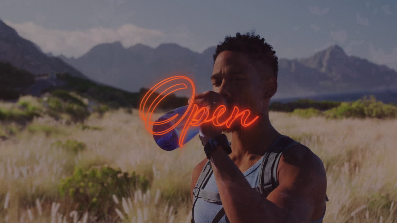 male hiker drinking water from bottle in grassy field, showing floating heart rate graph for health