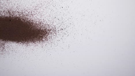 Video-of-close-up-of-brown-sand-grains-and-copy-space-on-white-background