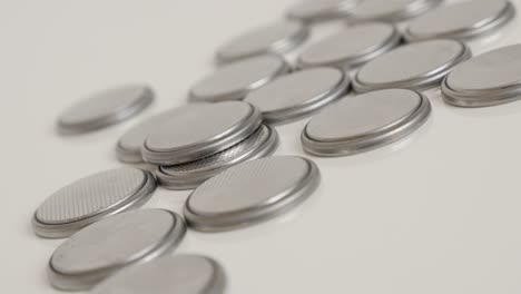 pile of watch batteries close-up slow tilt 4k video