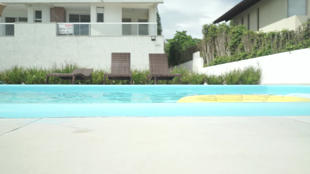 En smuk latinamerikansk pige i bikini nyder sin sommerferie i poolen på et luksuriøst hotel i Brasilien.