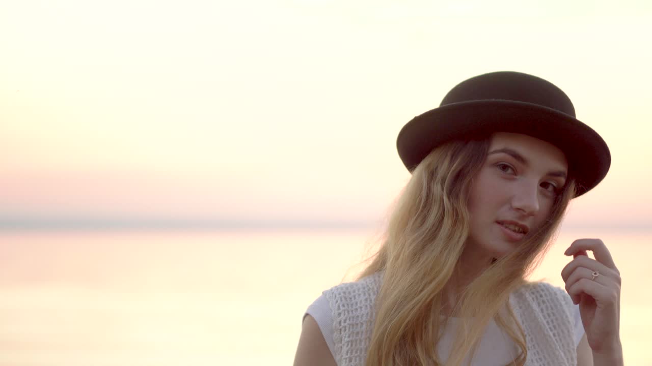 Woman in a Black Hat at Sunset