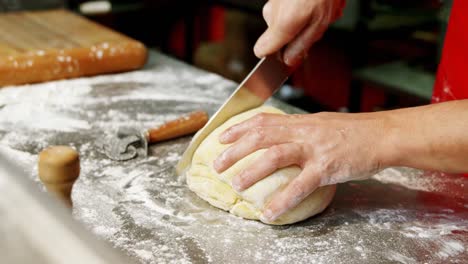 Männlicher-Bäcker-Schneidet-Teig-In-Bäckerei-4k