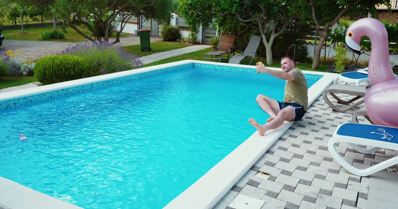 Mand skaber indhold til sociale medier ved en swimmingpool.