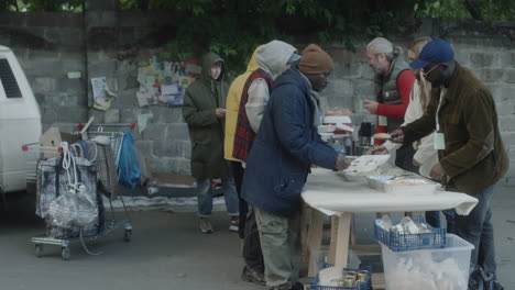 People serving and receiving food at an outdoor community outreach event