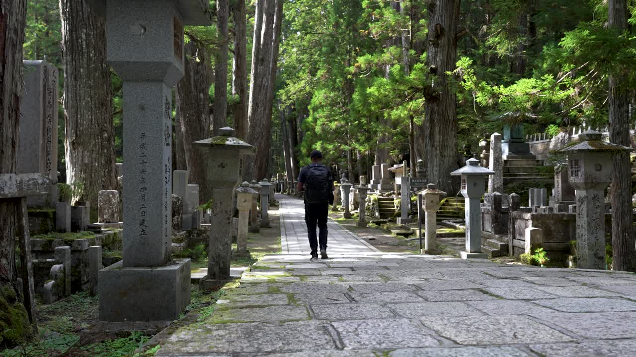 un mochilero solo caminando por el cementerio del bosque de okunoin en wakayama