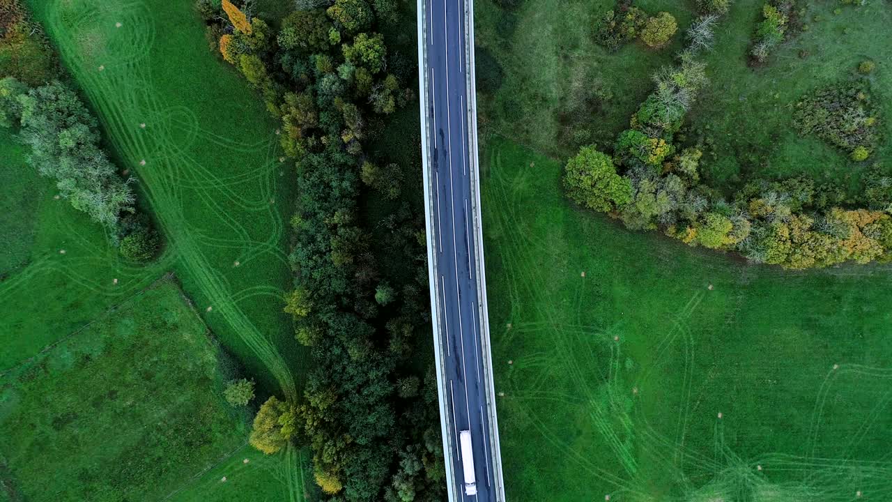 프랑스의 고속도로 위에서 아름다운 공중 풍경 - 도로 주변의 잔디과 나무, 태양 아래 도로에서 운전하는 자동차와 트럭.