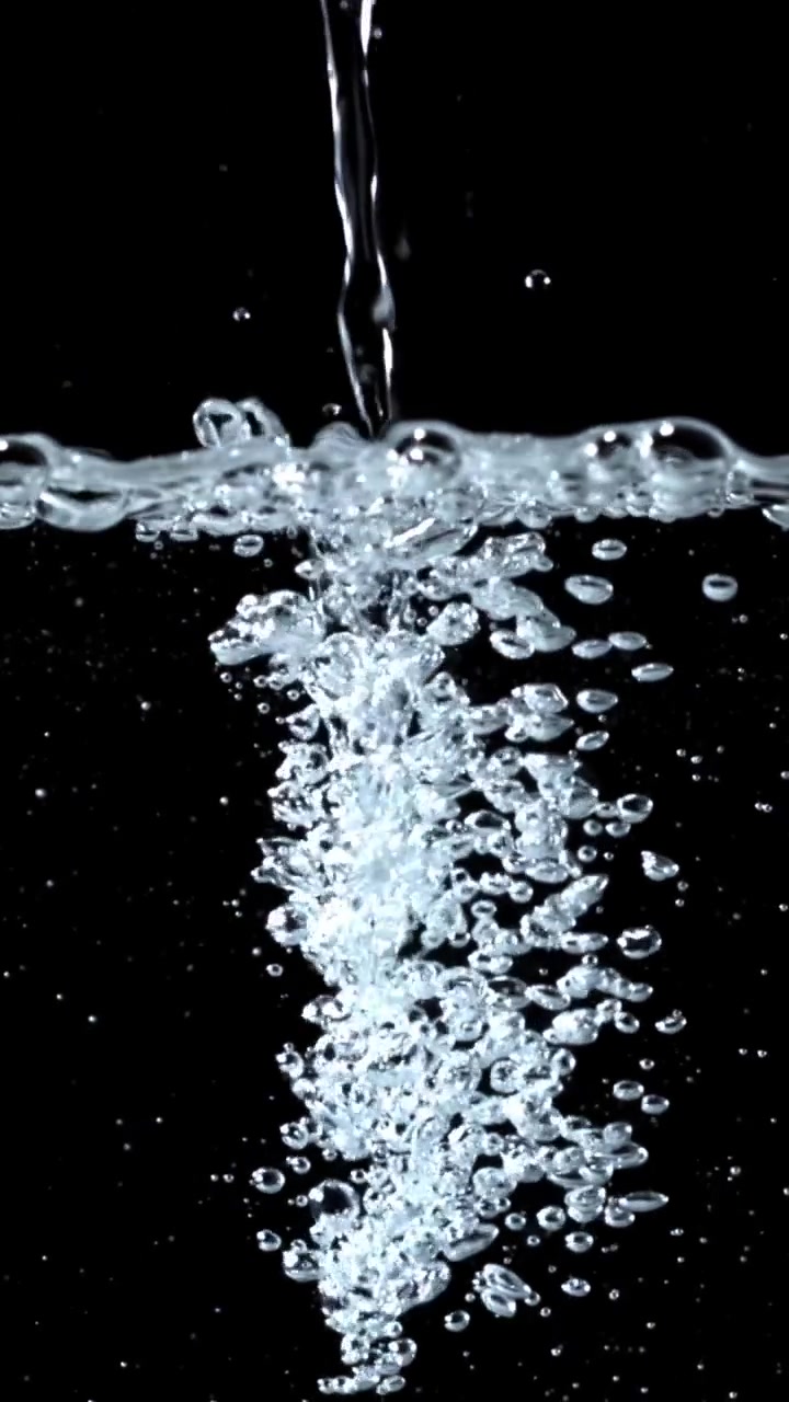Clear Water Stream Creating Bubbles Against Black