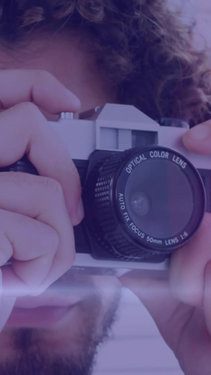 Punto luce su un fotografo afroamericano che scatta foto con una fotocamera digitale