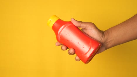 hand holding a ketchup bottle