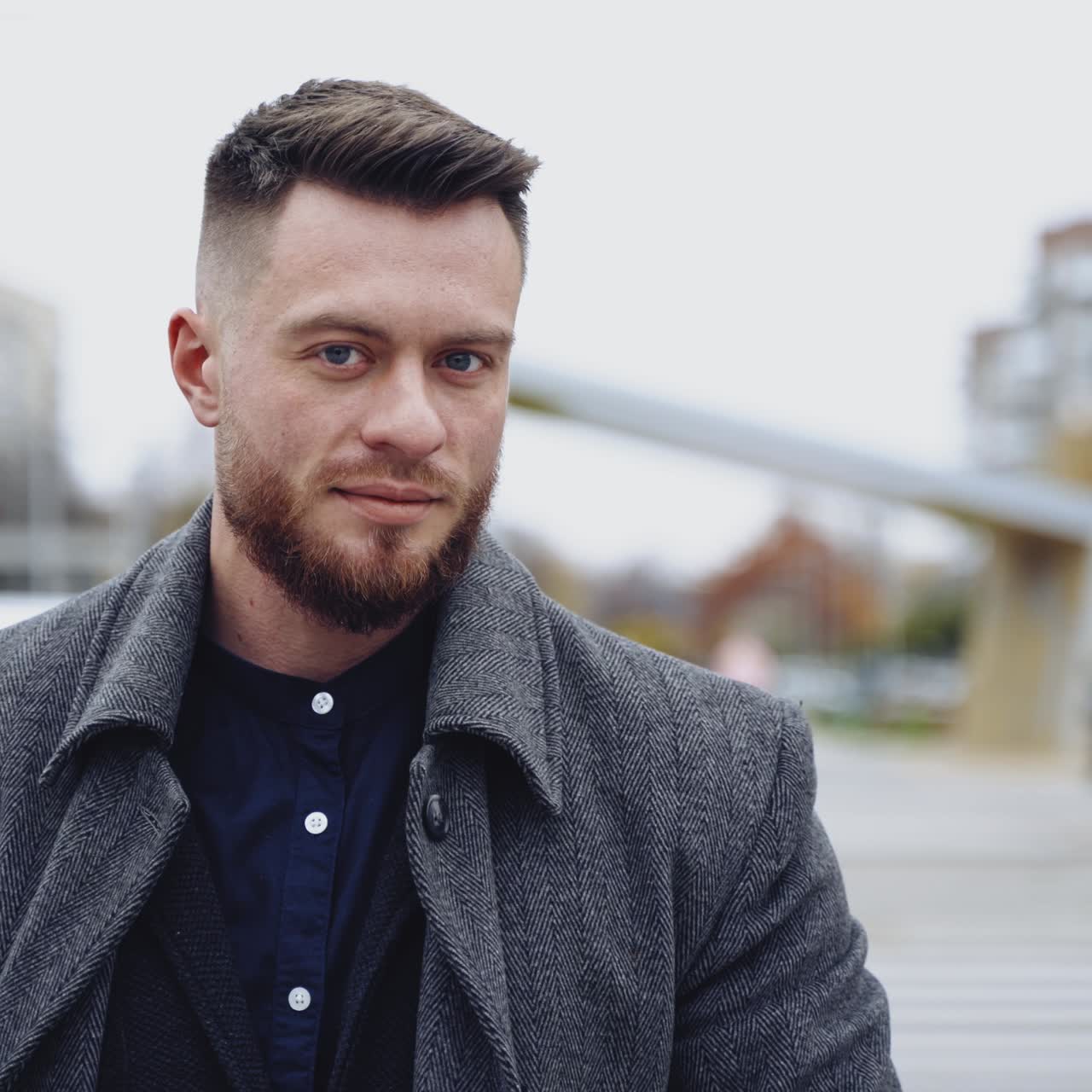 Handsome young man in grey coat and suit crossing the street and drinking coffe. Concept video