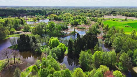 A Serene Patch of Land, Linked by Winding Bridges, Rests Among the Karst Lakes of Kirkilai in Biržai Regional Park, Lithuania - Aerial Drone Shot