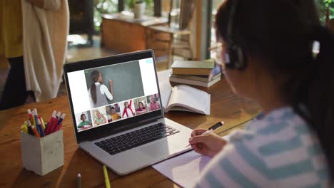 chica haciendo la tarea y teniendo una videoconferencia con el maestro y los compañeros de clase en la computadora portátil en casa