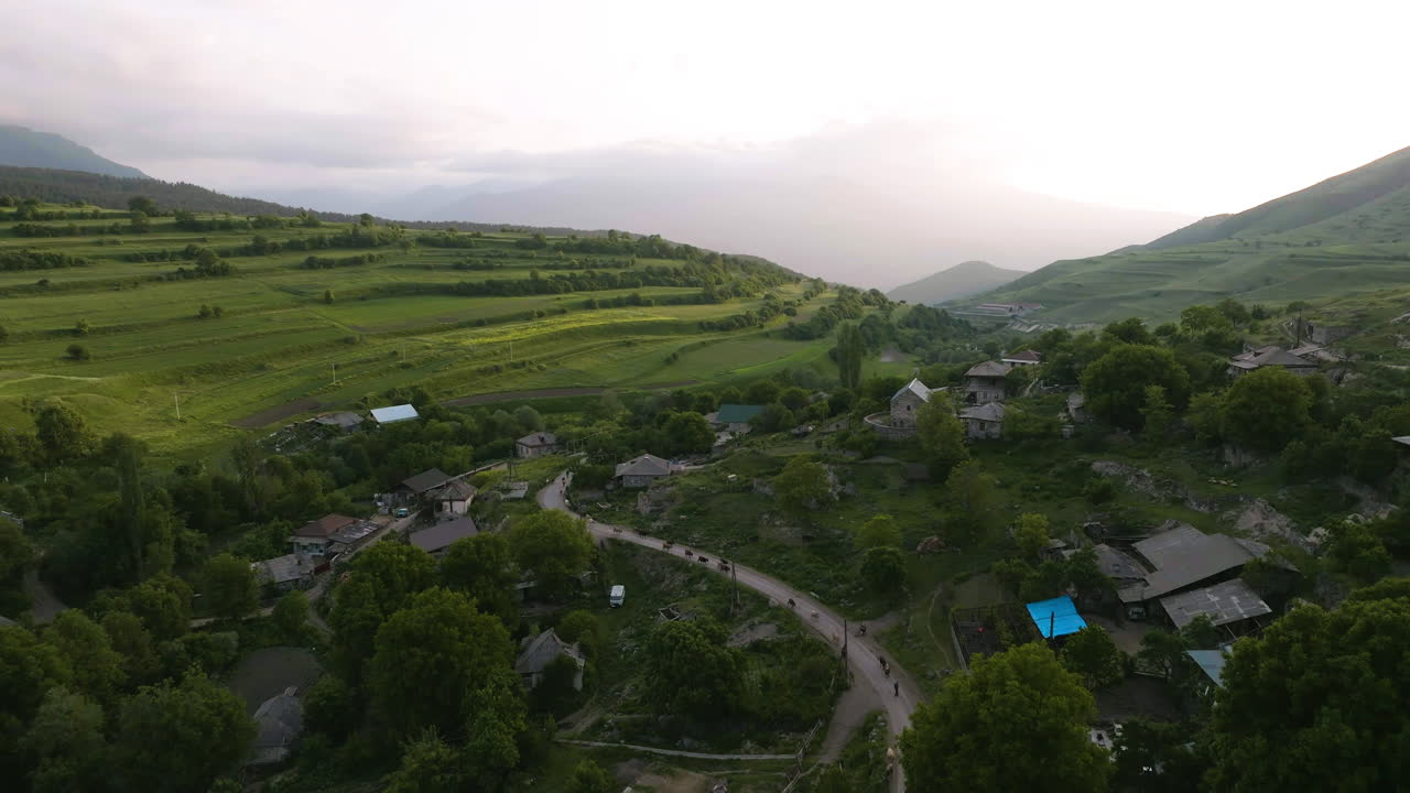 pastor y rebaño de vacas en la carretera de montaña caminando de regreso después de pastar en georgia