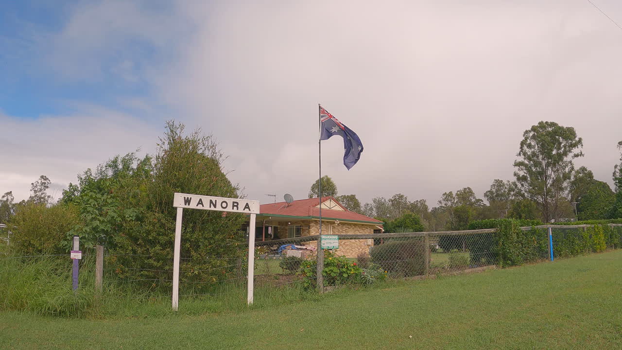호주 국기가 날아다니고 브리즈번 밸리 레일 트레일, qld 4k가 있는 오래된 철도 노선을 따라 있는 와노라 역 유적지