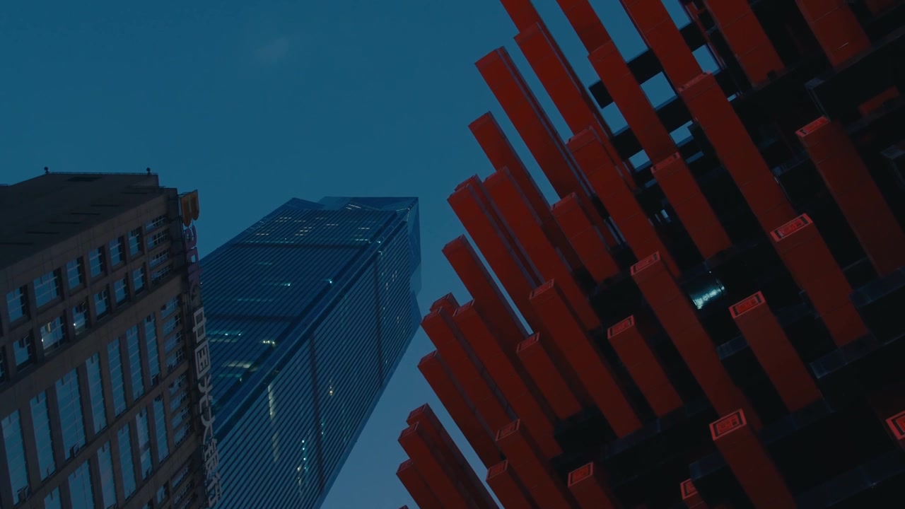 Chongqing Red Sculptural Installation with Stacked Beams Contrasting Glass Skyscraper at Dusk