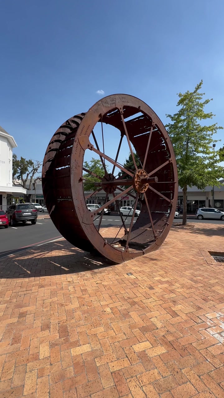 Roda air baja berkarat dari Nieuwe Molen (Penggilingan Baru) bersejarah yang digunakan untuk menggerakkan penggilingan gandum, dipajang di pusat Stellenbosch. Afrika Selatan