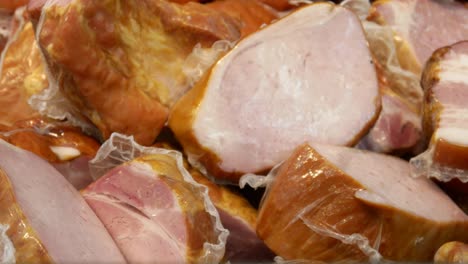 close-up of many peautiful delicious hams and a male buyer's hand takes one