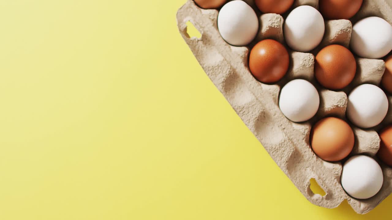Video of eggs in packaging box on a yellow surface