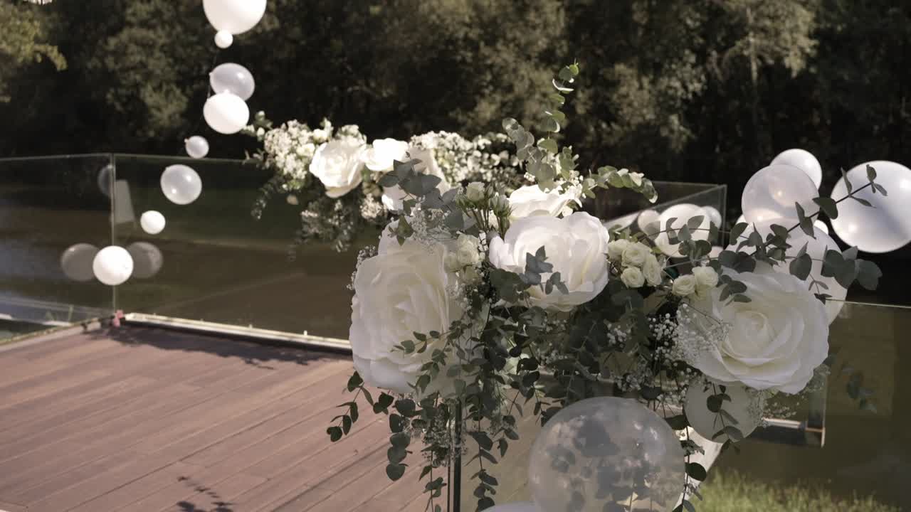 Eleganti decorazioni nuziali all'aperto con rose bianche e palloncini