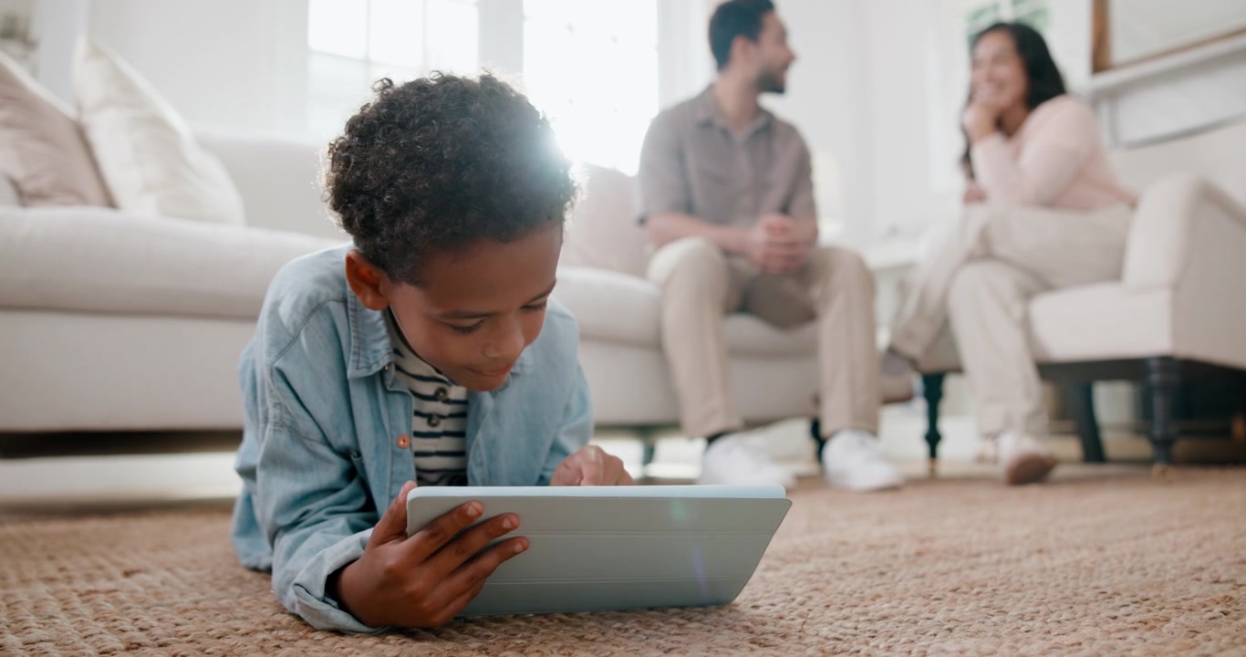 Young Boy Using Digital Tablet on Living Room Floor