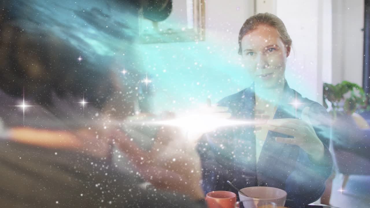 Woman facing camera speaking, gesturing, starting nebula swirl sweeping cups, showing design idea